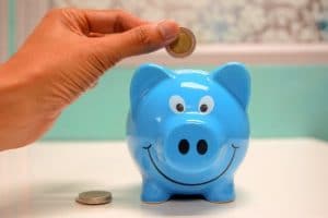 blue piggy bank with coin going in